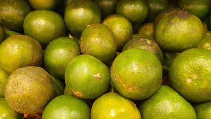 Close up pile of tasty fresh limes sold at the market as a background.