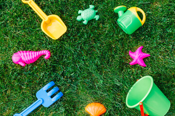 childhood and summer concept - close up of sand toys kit on green lawn or grass