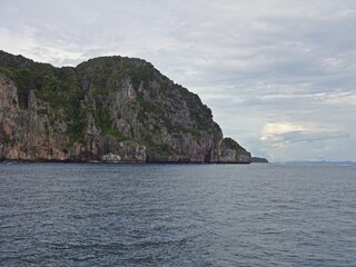 Fototapeta na wymiar The serene blue sea is complemented by a majestic mountain towering above it, PHI PHI ISLAND, THAILAND 