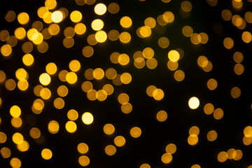 Fundo preto com luzes amarelas desfocadas em bokeh.