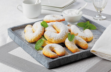 Austrian vanilla cookies in the shape of half moons sprinkled with icing sugar..