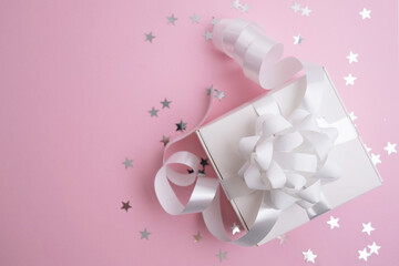 Gift or present box and confetti with stars on a colored background. Gift for birthday, mother's day or wedding. Place for text
