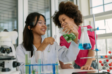 Engaged young girl learns about scientific experiments from a female scientist in a laboratory...