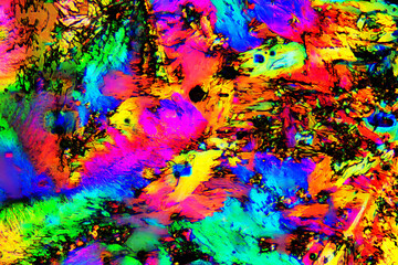 Extreme macro photograph of Tartaric Acid crystals forming vibrant abstract modern art patterns, when illuminated with polarized light, under a microscope objective with 50x magnification