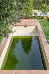 A swimming pool has green water due to dirt and algae and needs maintenance