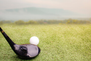 Golf ball placed on grass, background with bokeh and flare.