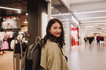 Fototapeta na wymiar Beautiful teen girl holding shopping bags and smiling while doing shopping in mall