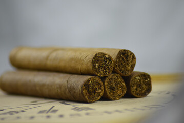 Fünf braune Zigarren liegen auf einer Holzkiste auf weißen Hintergrund