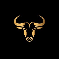 Elegant golden bull head with sharp horns on a stark black background, capturing the essence of strength and power