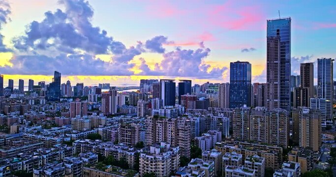 Aerial forward shot of Zhuhai modern city crowded architectural landscape at sunset