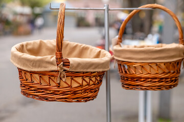 baskets with a brown cloth on top of them are hanging on a metal pole