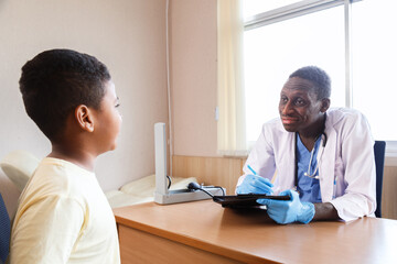 african american man pediatrician doctor talking to examining a boy from sickness in the office at the hospital. medical and healthcare lifestyle services.