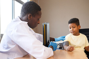 african american man pediatrician doctor measuring blood pressure  and exam a boy from sickness in...