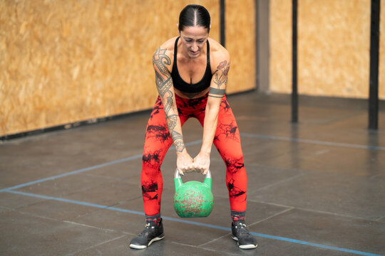 Woman working out using kettlebell in a gym
