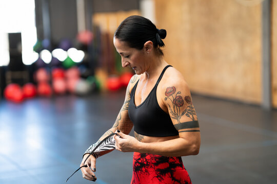 Woman protecting her wrists with wraps before training