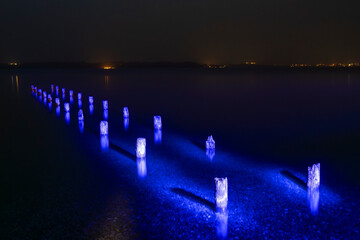 Ehemaliger Steg am Starnberger See mit blauem Licht bemalt - obrazy, fototapety, plakaty