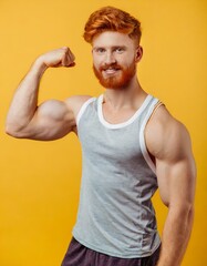 Man Flexing His Muscles isolated on yellow background. sportive young man arms showing biceps