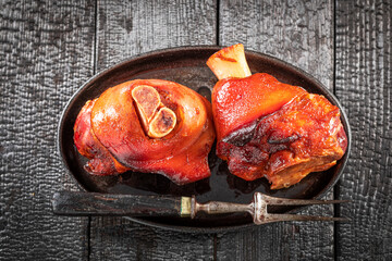 Tasty and hot pork knuckle2 baked with spices in casserole. - obrazy, fototapety, plakaty
