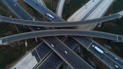Obraz premium Urban mobility: exploration of multi-level interchanges via drone. Cinematic shot of cars in motion capturing urban mobility from above. Dynamic flow of city life concept from unique perspective