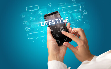 Hand using smartphone with social media concept