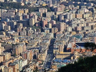 Obraz premium Genova, Italy - March 24, 2024: Aereal view to the city of Genoa with beautifull blue sea in the background. Sunny spring day over the city. Modern and old architecture mix.
