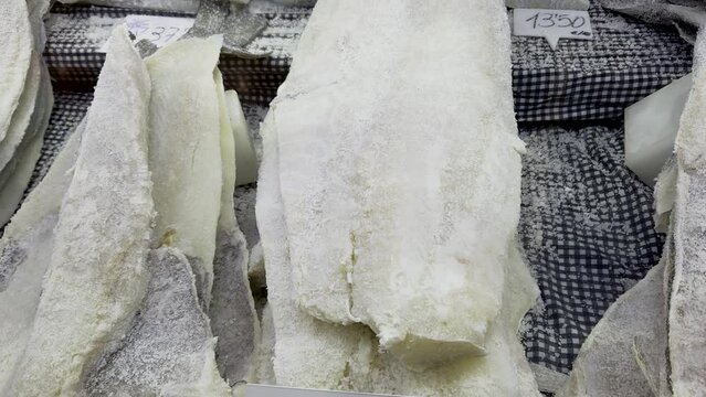 Culinary heritage and traditional style of preserving cod fish. The display showcases salted cod, a traditional delicacy found in Mediterranean markets. Perfect for food enthusiasts, travel blogs, and