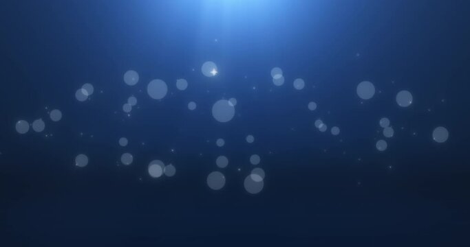 Bokeh particles in fog among sparkling stars on blue background under a light source. Abstract animation.