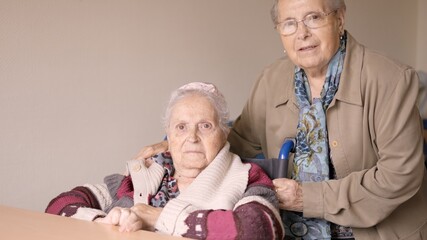 Senior women looking at camera together in a nursing home