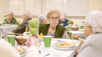 Senior woman eating in a dining room of geriatric