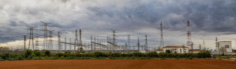 electrical substation and high voltage towers on a cloudy dayu