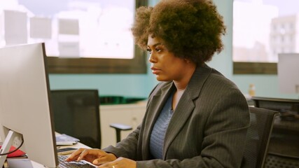 Concentrated woman working using computer in a coworking