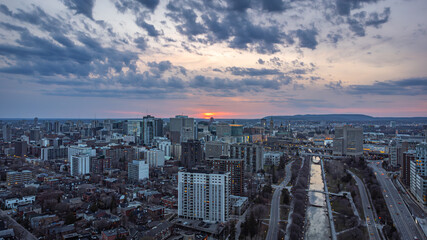 Aerial panoramic breathtaking view of sunset over Rideau Canal, Parliament Hill, downtown Ottawa, Ontario and Gatineau, Gatineau Park Hills, Outaouais, Quebec, Canada (Drone photo, April 2021)