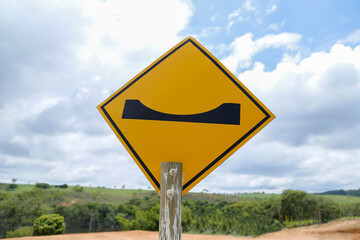 yellow traffic sign indicating depression - warning signage