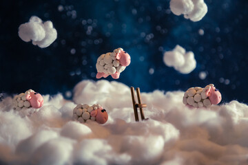 Cute plasticine sheep jumping over a fence in the clouds.