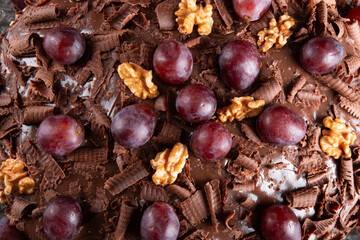 Cake with chocolate icing and grapes close up - 772470506