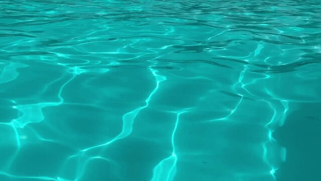 An amazing view of swaying blue waters in a modern swimming pool with shimmering curvy lines making a cheerful and arty background.  abstract background animation: sea, swimming pool, water (4K)