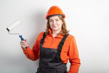 A painter girl with a roller for painting walls.. Painting the walls of the house.