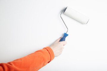 A painter girl with a roller for painting walls.. Painting the walls of the house.