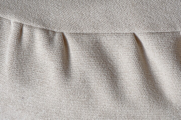Light creamy fabric texture with curved seam and seam pleats