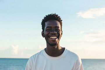 Portrait of a smiling young man with the ocean in the background during sunset.