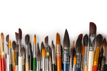Mix of paint brushes in a row isolated on a white background.  Top view.