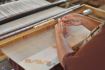 weaving craftsmen who is weaving cloth using traditional looms in donggala, Indonesia.