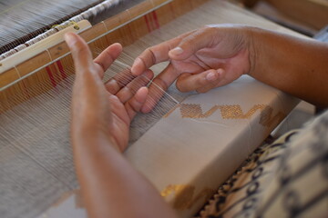 weaving craftsmen who is weaving cloth using traditional looms in donggala, Indonesia.