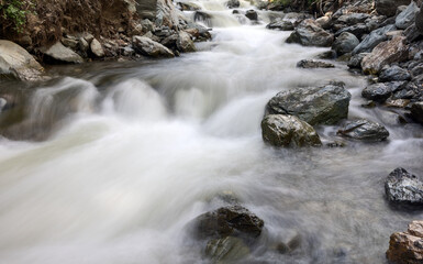 small fast river running between rocks - 772496919