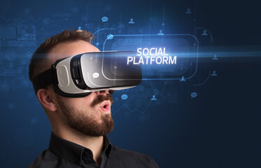 Businessman looking through Virtual Reality glasses, social media concept