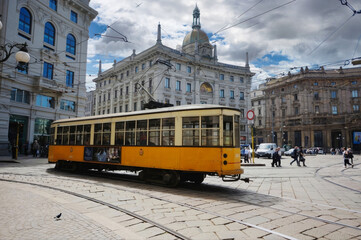 Vintage Yellow Tram in Motion, Milan, Italy with Historical Buildings