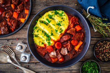 Irish stew for St. Patrick's Day - roast beef in beer with potato puree  served on wooden table
