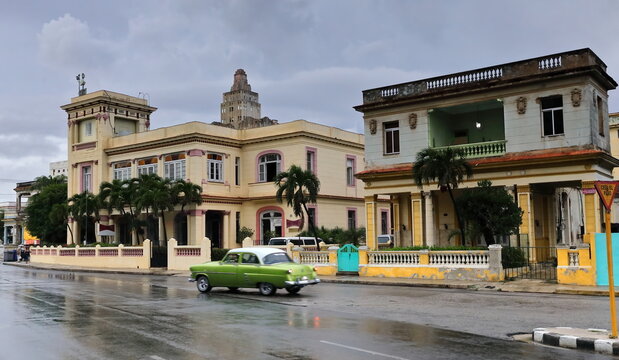 Old green almendron car -1953 Ford classic- drive down Calle 15 Street to enter Linea Street in the aftermath of a strong rainstorm. Havana-Cuba-129