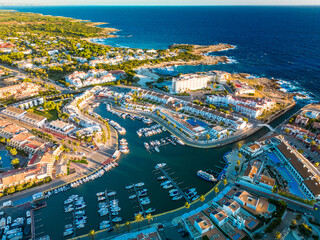 Aerial drone view of the harbor and the beach of Cala en Bosc, Menorca.