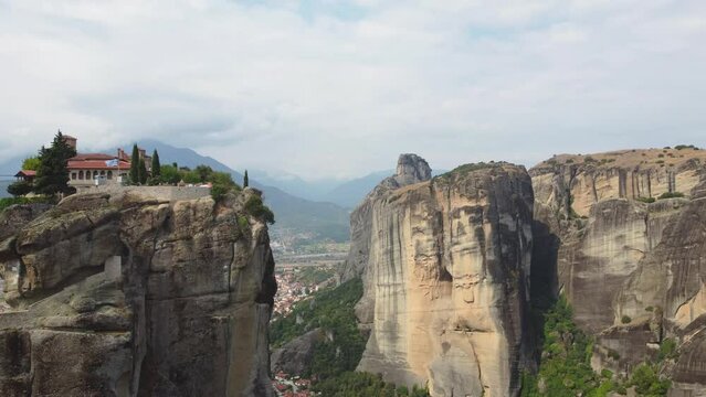 Aerial view of Monastery of the Holy Trinity (Agia Triada) in Meteora, Greece with Kalabaka town and mountains in the background